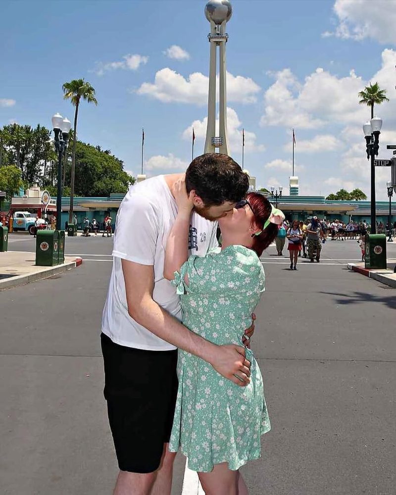 Arran and Imogen sharing a kiss at the gates of Disney World